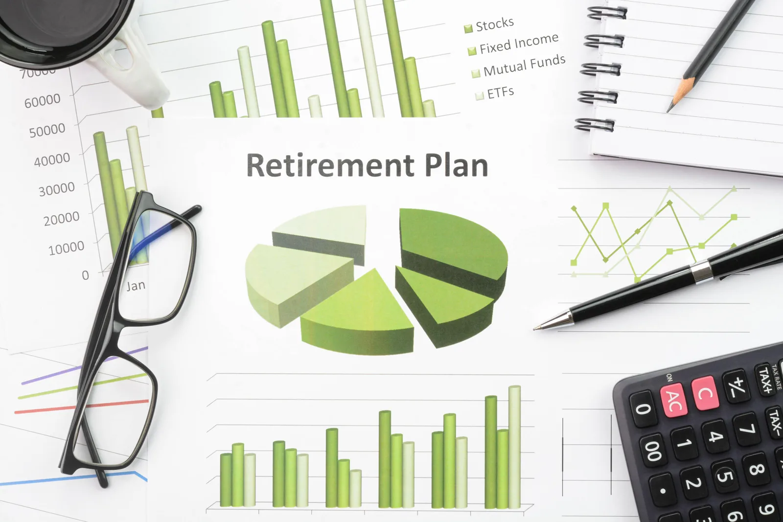 Person reviewing financial documents and charts at a desk